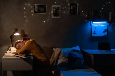 College student struggling to sleep in a noisy dorm room