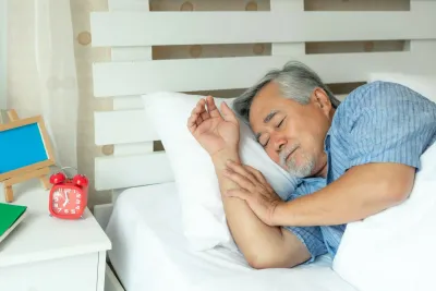 Older man in bed sleeping